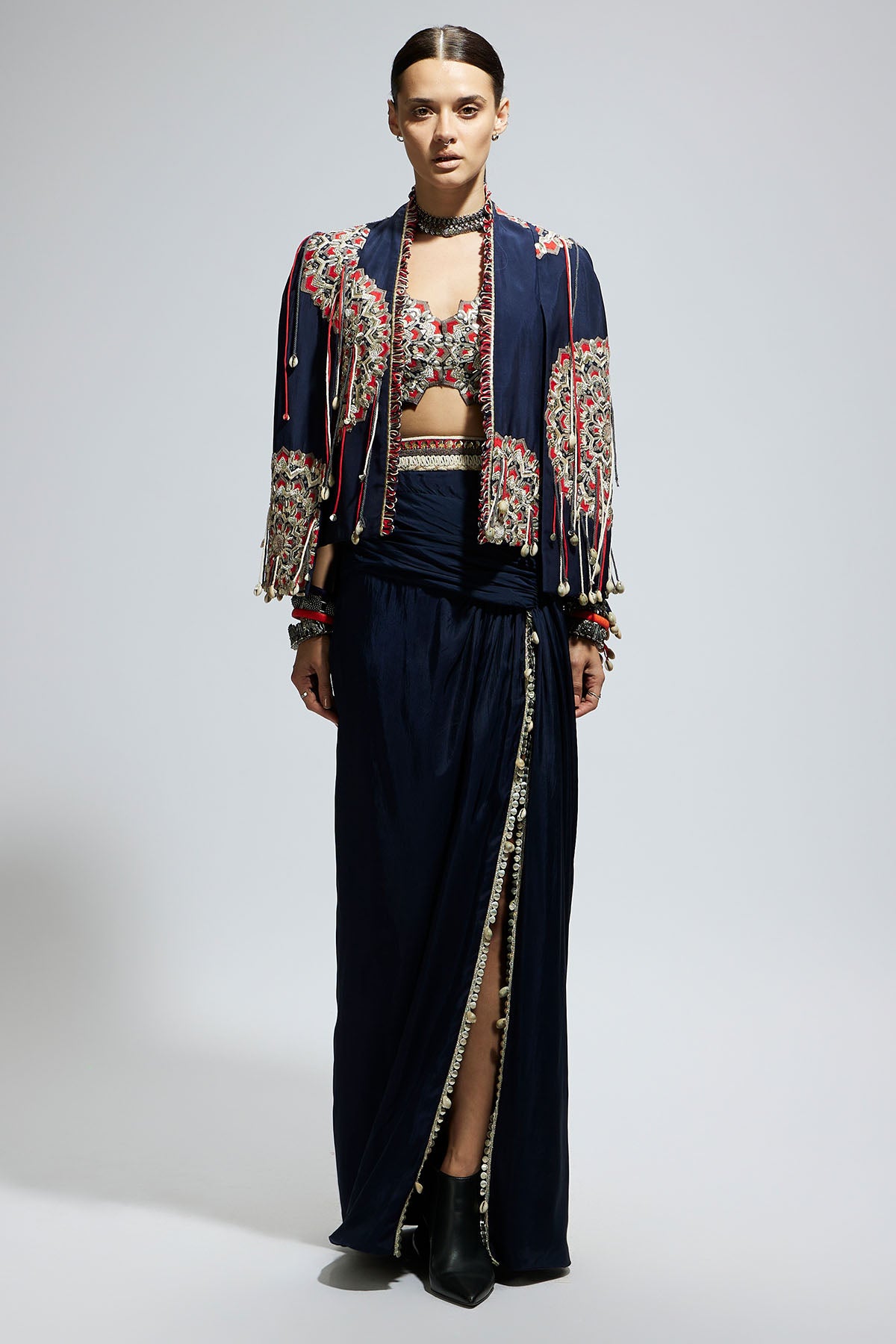 Blue Asymetric Threadwork Cape Jacket Paired with An Embellished Bustier and High Slit Skirt