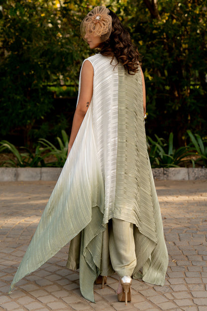 Box pleat pants and an embroidered vest are paired with a long cape